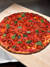 A pizza with pepperoni and basil on top of it.