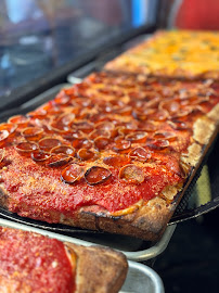 A pizza sitting on top of a pan covered in sauce.