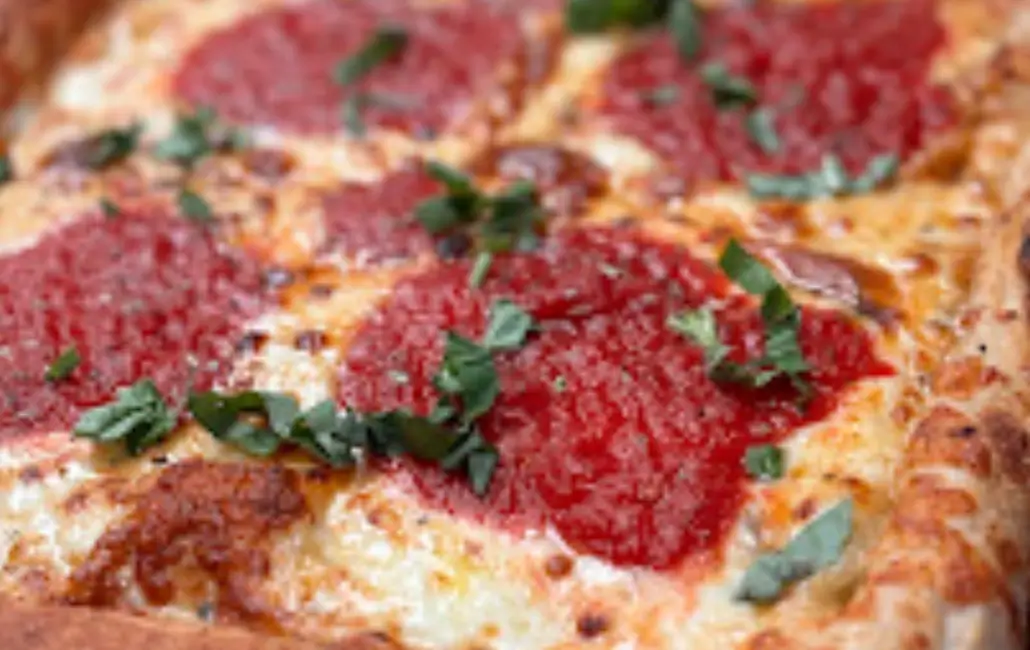 A close up of some pizza with sauce and parsley