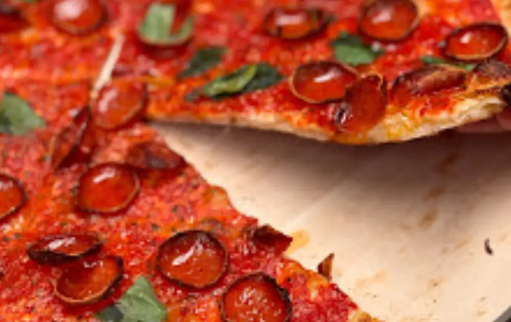 A close up of pepperoni pizza slices on paper